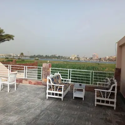 a group of chairs and tables on a patio at Al Baba Nile Villa in Luxor