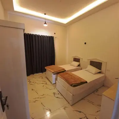 two beds in a room with a marble floor at Al Baba Nile Villa in Luxor
