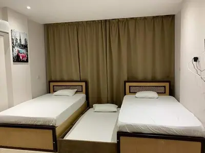 two twin beds in a room with curtains at شاليه داخل ميراج اكوا بارك عائلات فقط غير مخصص للشباب in Hurghada