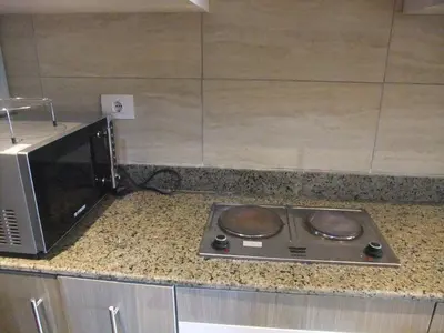 a kitchen counter with a stove and a microwave at Sky Relax ALDAU HEIGHTS in Hurghada