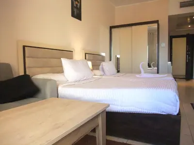 a hotel room with two beds and a mirror at Sky Relax ALDAU HEIGHTS in Hurghada