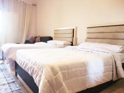 two beds in a hotel room with white sheets at Sky Relax ALDAU HEIGHTS in Hurghada