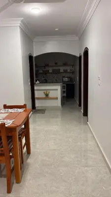 a living room with a table and a kitchen at Villa Muhammad in Quseir