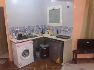 a kitchen with a sink and a washing machine at ALHASANI APARTMENT in Hurghada