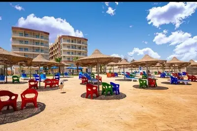 a beach with colorful chairs and umbrellas on the sand at Kazpilkna Beach Neighborhoods in Hurghada