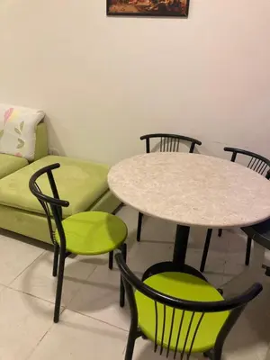 a living room with a table and chairs and a couch at Nice 2-Bed Apartment in Hurghada