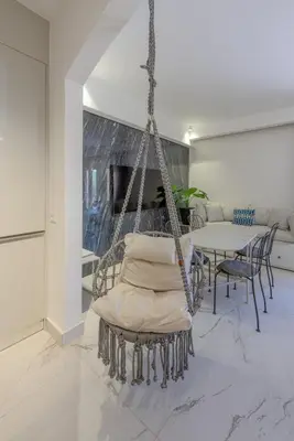 a swinging chair in a living room with a table at Stylish Nest - New Marina - El Gouna in Hurghada