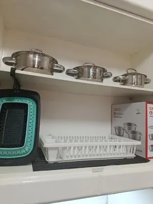 a kitchen shelf with pots and pans and a tv at Turtles Beach Resort in Hurghada