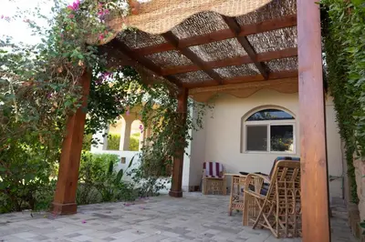 a pergola with chairs and tables on a patio at Beautiful 2-Bed Villa in Makadi Heights in Hurghada