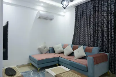 a living room with a blue couch with pillows at Beautiful 2-Bed Villa in Makadi Heights in Hurghada