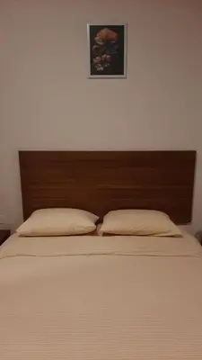 a bed with a wooden headboard and two pillows at Hurghada Aldau Heights Studio in Hurghada