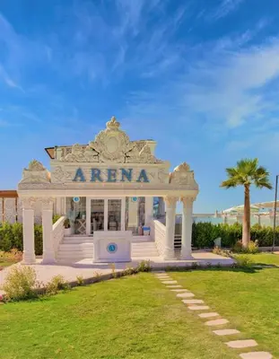 a white entrance to a building with a palm tree at selena bay resort in Hurghada