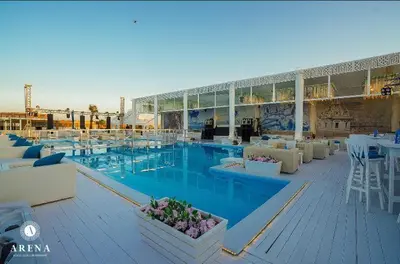 a large swimming pool with tables and chairs in a building at selena bay resort in Hurghada