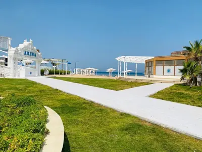 a walkway in front of a white building and the ocean at selena bay resort in Hurghada