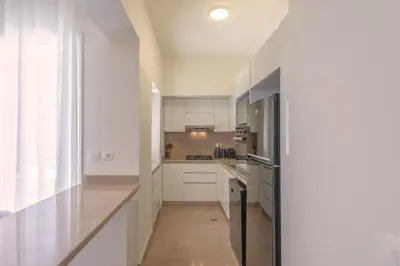 a kitchen with white cabinets and stainless steel appliances at Beach Front Paradise - 3 master beds - Abu Tig Marina - El Gouna in Hurghada