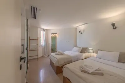 a white room with two beds and a window at Beach Front Paradise - 3 master beds - Abu Tig Marina - El Gouna in Hurghada