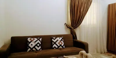 a living room with a brown couch with two pillows at Relax Home 1 in Hurghada