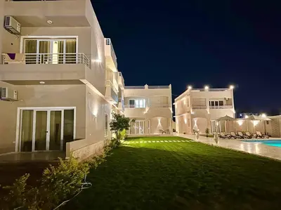 a large white house with a yard at night at Royal Nile Suites - Luxury Nile View 2 in Luxor