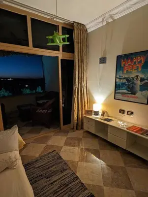 a bedroom with a bed and a view of a living room at Aswan Nile view Family apartment in Aswan