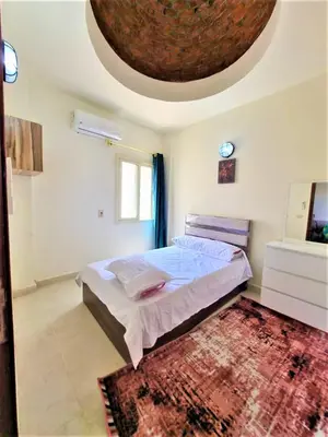 a bedroom with a large bed and a ceiling at 2 bedroom quiet flat at makadi heights in Hurghada