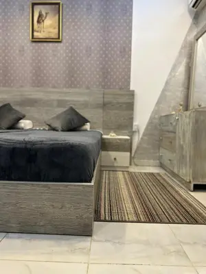 a bedroom with a bed and a dresser and a rug at Horizon on Mamsha 2 in Hurghada