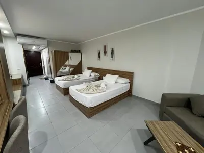 a hotel room with two beds and a couch at Luxury Seaview Apartment with Pool Scandic Resort Hurghada in Hurghada