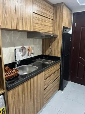 a kitchen with a sink and a black refrigerator at Luxury Seaview Apartment with Pool Scandic Resort Hurghada in Hurghada