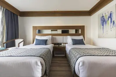 a hotel room with two beds and a desk at Nile Cruise from Aswan to Luxor 3 Night And Luxor to Aswan 4 Night in Jazīrat al ‘Awwāmīyah