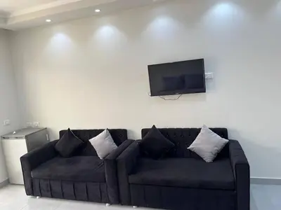 a black couch in a living room with a flat screen tv at Scandic Resort in Hurghada