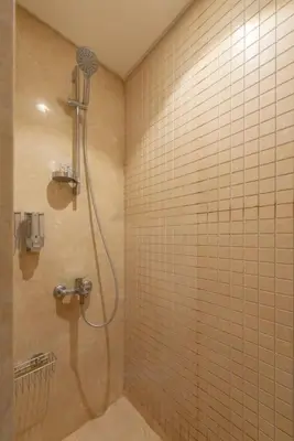 a shower in a bathroom with a tiled wall at Modern 1BR, Mangroovy, Gouna - 1BR, Pool, & Beach in Hurghada