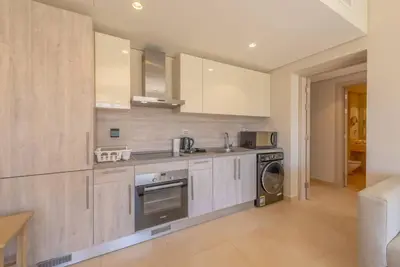 a kitchen with a stove and a washer and dryer at Modern 1BR, Mangroovy, Gouna - 1BR, Pool, & Beach in Hurghada
