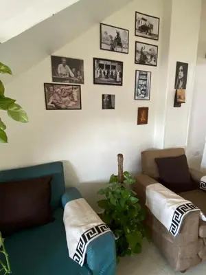 a living room with a couch and pictures on the wall at luxor Nile view duplex apartment in Luxor