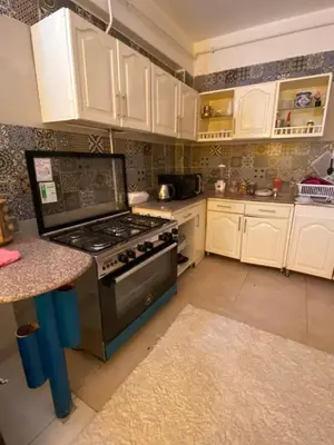 a kitchen with white cabinets and a stove top oven at luxor Nile view duplex apartment in Luxor