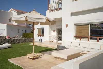 a patio with a white couch and an umbrella at The Sandy Feet Sea Front in Hurghada