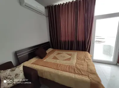 a bedroom with a bed and a window with curtains at Tiba View in Hurghada
