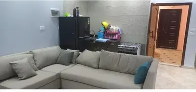 a living room with a white couch with pillows at Ikea flat 9 in Hurghada