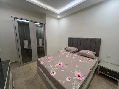 a bedroom with a bed with pink flowers on it at Apartment 2 bedroom and 2 Bathroom pool view at mirage bay in Hurghada