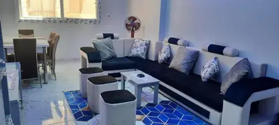 a living room with a couch with pillows on it at New Apartment for short and long term in Hurghada