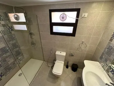 a bathroom with a toilet and a shower and a window at The View Club House in Hurghada