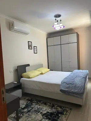 a bedroom with a bed with a large white cabinet at The View Club House in Hurghada
