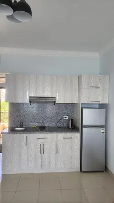 a kitchen with white cabinets and a refrigerator at Studio in old Sheraton in Hurghada