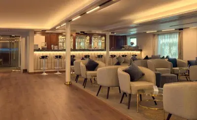 a room with chairs and tables and a bar at live Nile in style Nile cruise in Luxor and Aswan in Luxor