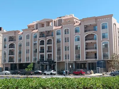 a large building with cars parked in a parking lot at 2 room Appartement in Hurghada