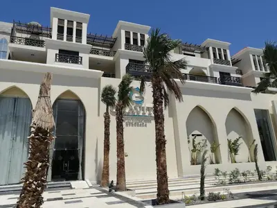 a white building with palm trees in front of it at Private Room Hurghada for rent beach and pools included Not Valid for Locals in Hurghada