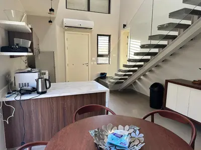 a kitchen with a wooden table and a staircase at El Gouna Cyan Villa with pool n lagoon by BFG Beit Fel Gouna in Hurghada
