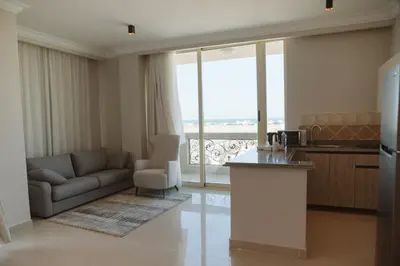 a living room with a couch and a kitchen with a view at TK Royal & Spa in Hurghada