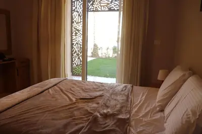 a bedroom with a bed and a window with a view at Cozy Ground floor-Pool view - Mangroovy El Gouna in Hurghada