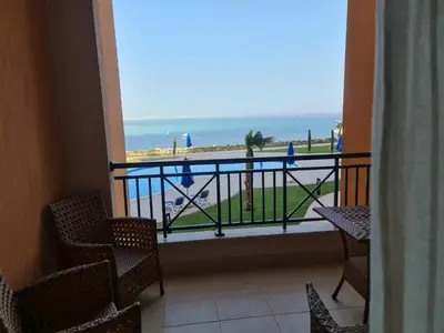 a balcony with chairs and a view of the beach at One bedroom in the view in Hurghada