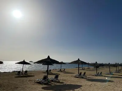 a group of chairs and umbrellas on a beach at One bedroom in the view in Hurghada
