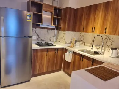 a kitchen with a stainless steel refrigerator and wooden cabinets at One bedroom in the view in Hurghada